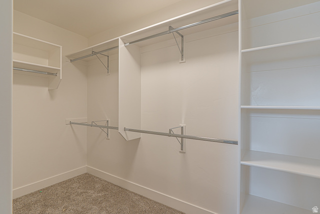 2257 South 1090 West, Unit 74 Nibley, UT 84321 - Photo 19 of 40 Walk-in closet featuring built-in shelving, multiple hanging rods, and light-colored carpeting