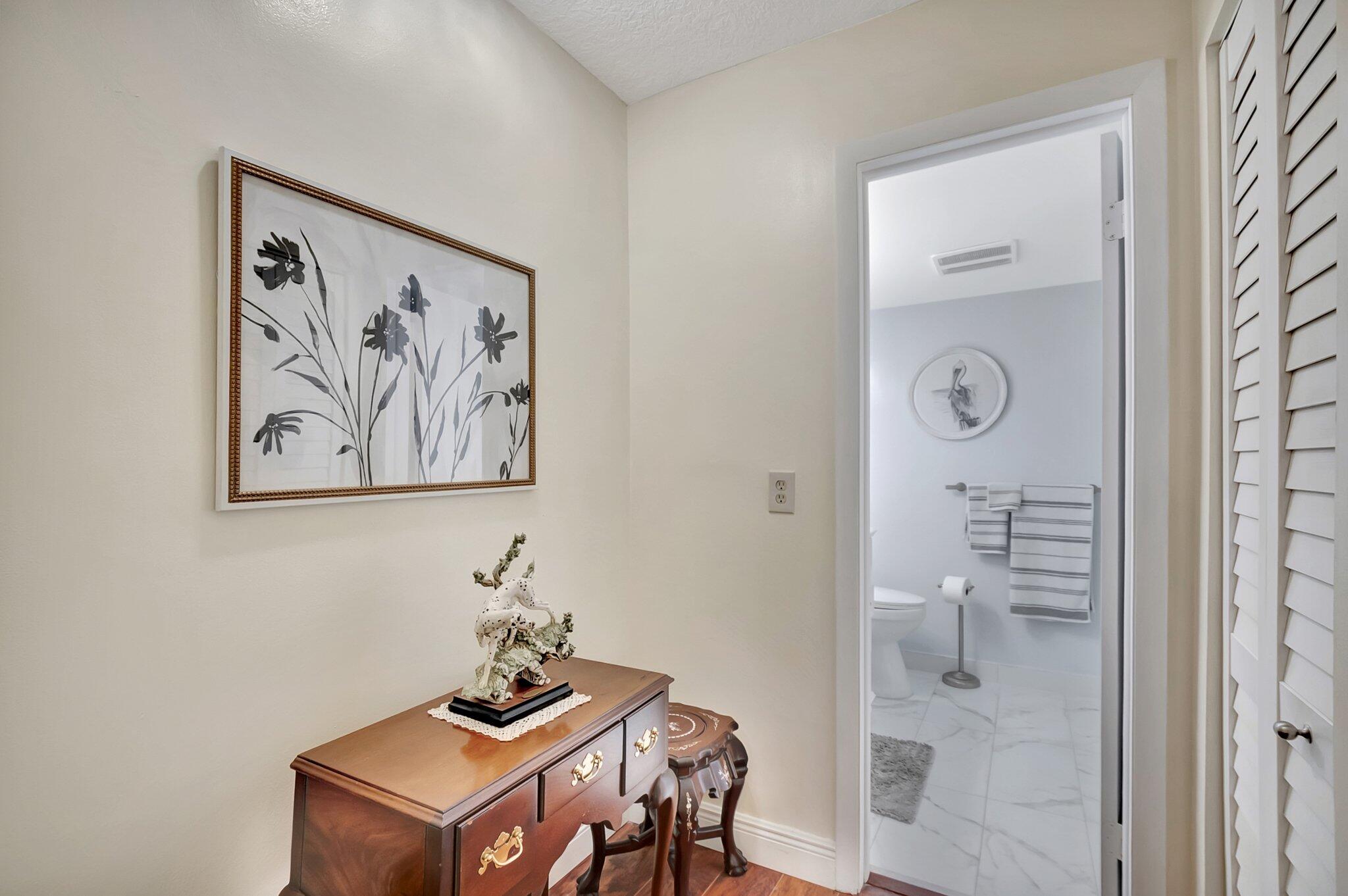 6461 Northwest 2nd Avenue, Unit 1160 Boca Raton, FL 33487 - Photo 16 of 26 a view of a hallway that has a table and potted plant in it