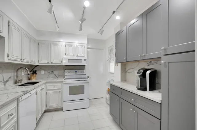 a kitchen with white cabinets stainless steel appliances and sink
