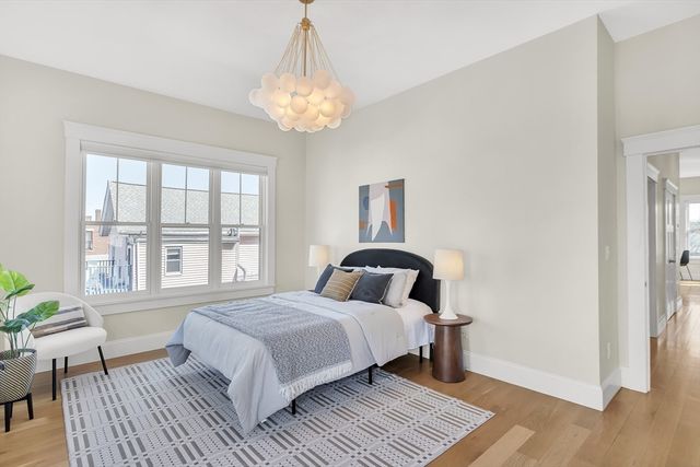 a bedroom with a bed and a chandelier