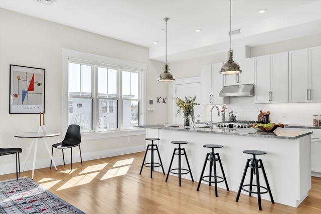 a kitchen with stainless steel appliances granite countertop white cabinets and wooden floor