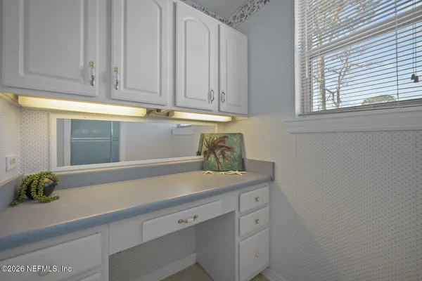 a kitchen with stainless steel appliances white cabinets and a window