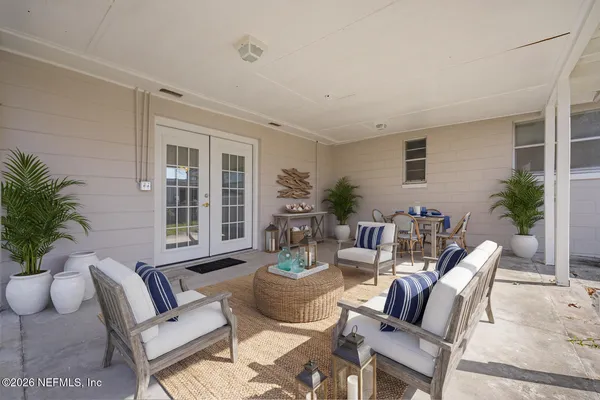 a living room with furniture and potted plants