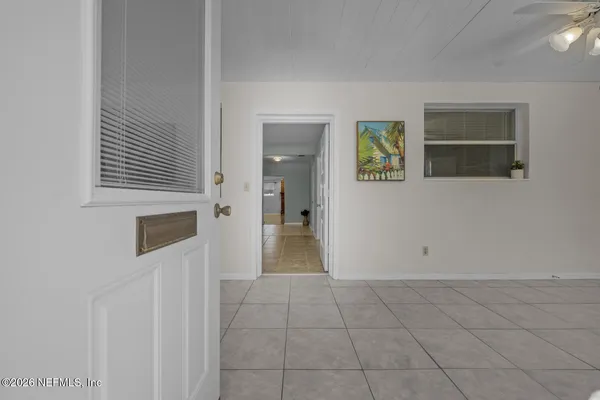 a view of a hallway with wooden floor and a living room