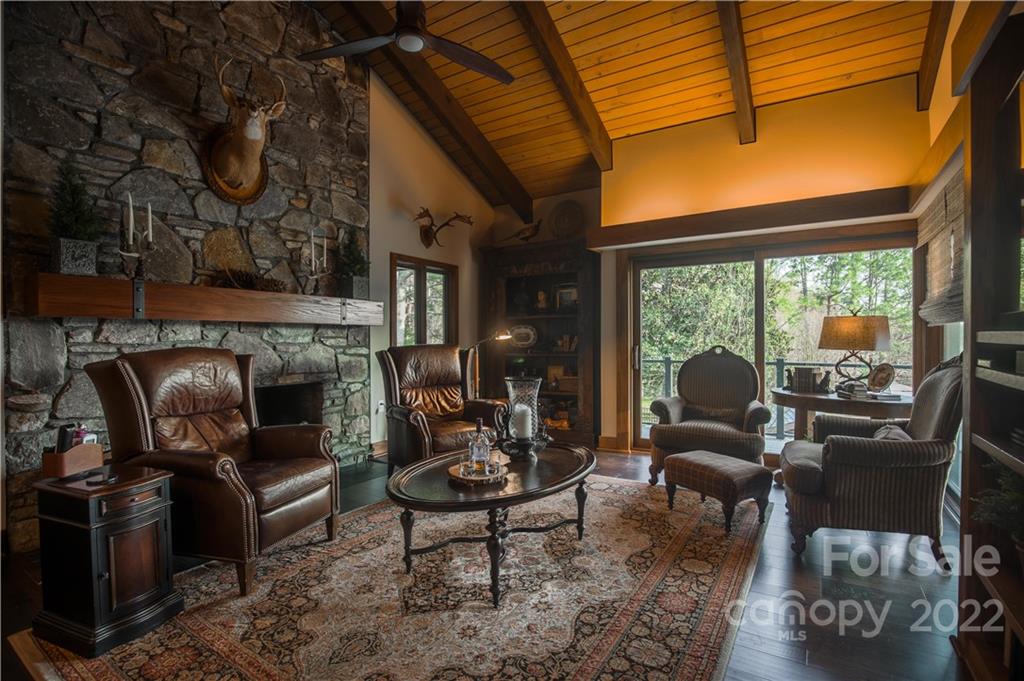 560 Club Road Tryon, NC 28782 - Photo 21 of 48 a living room with furniture a fireplace and a floor to ceiling window