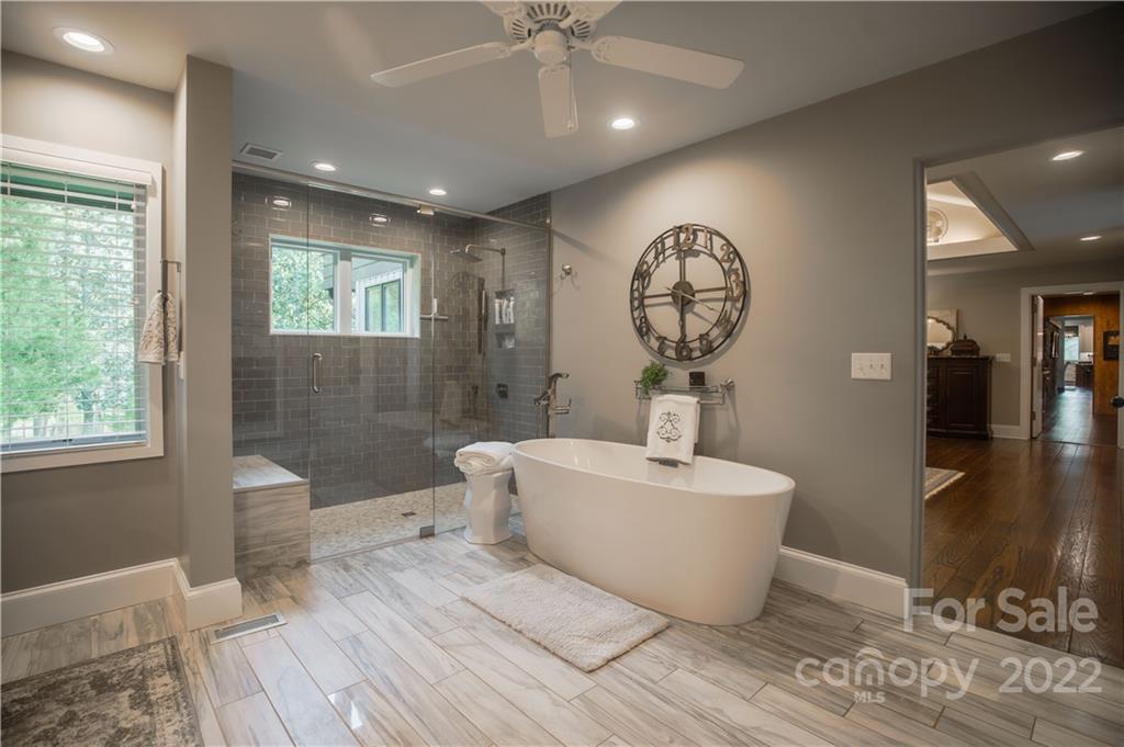 560 Club Road Tryon, NC 28782 - Photo 29 of 48 a spacious bathroom with a white tub shower and a mirror