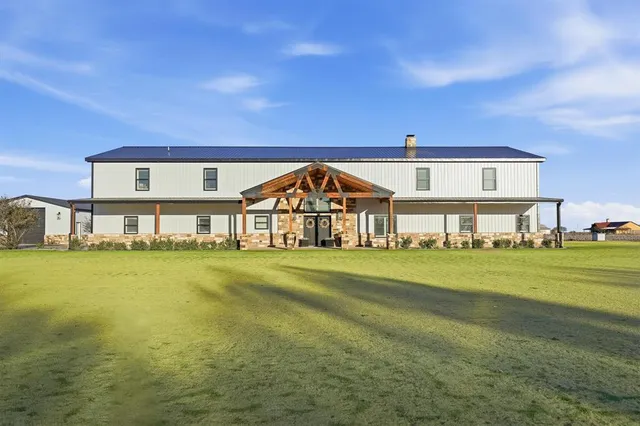 a view of a big house with a big yard and large trees