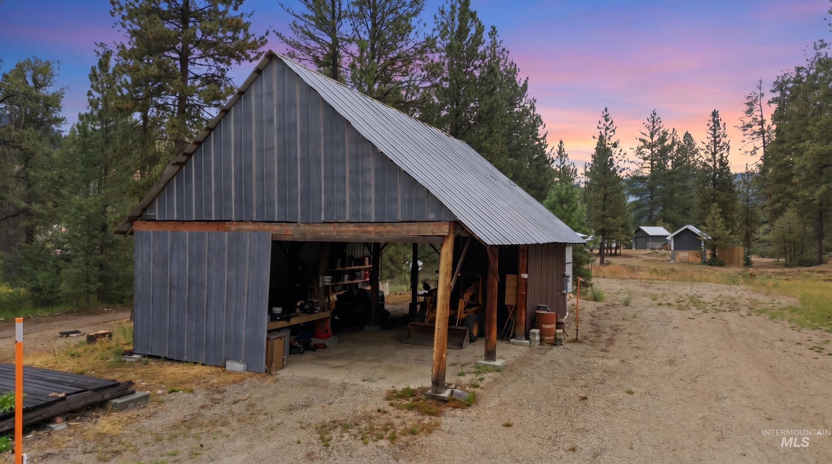 3980 North Pine-Featherville Road Mountain Home, ID 83647 - Photo 12 of 35 Wood-sided barn structure featuring a metal roof and an open-sided bay