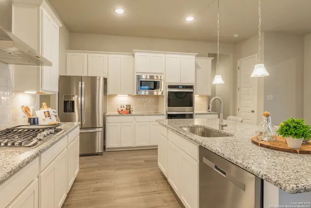 a kitchen with refrigerator a sink and microwave