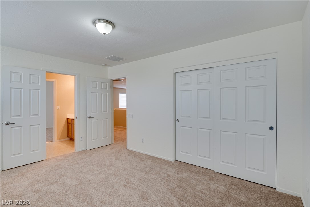 2717 Rimbaud Street Henderson, NV 89044 - Photo 30 of 34 A well-lit bedroom provides ample space and convenient access to an adjoining bath and hallway.