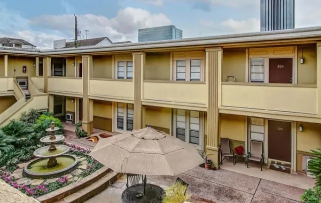 a view of a patio with table and chairs potted plants and large tree