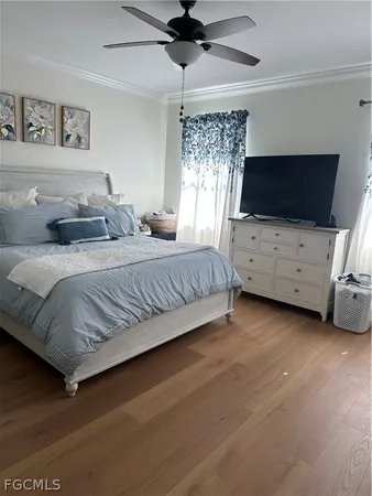 a bedroom with a bed a flat screen tv and dresser