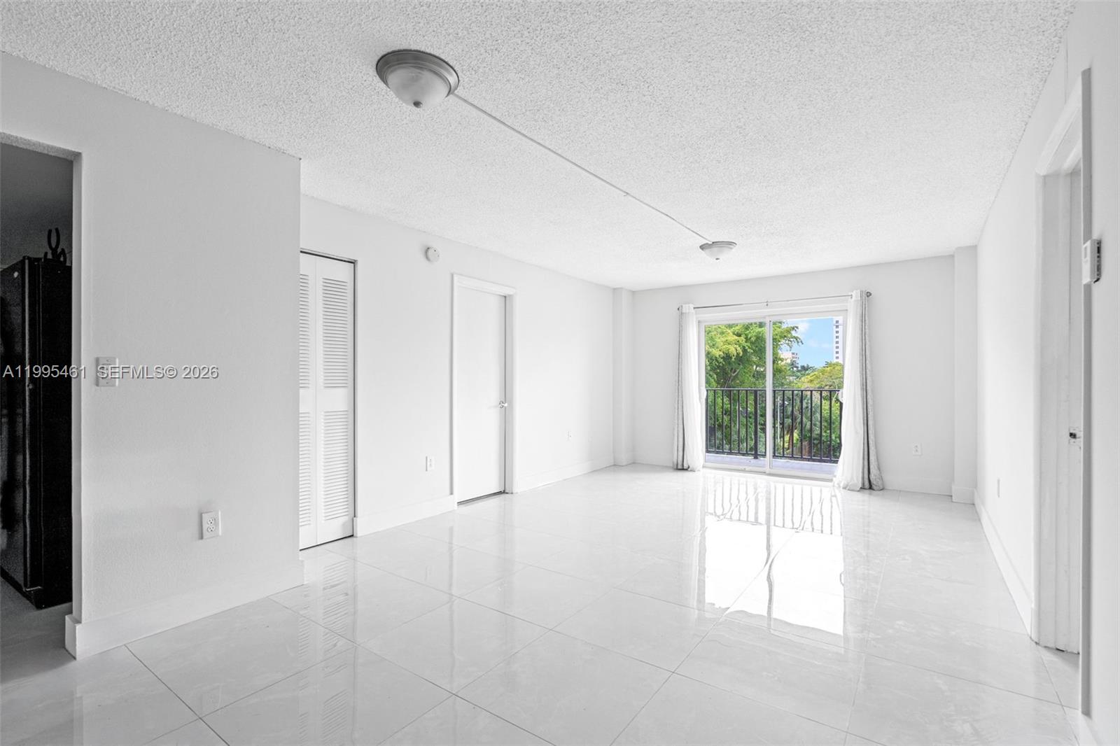 4801 Northwest 7th Street, Unit 40716 Miami, FL 33126 - Photo 1 of 26 a view of an empty room with a window