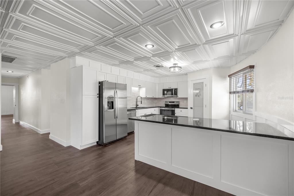 6391 Southeast 186 Terrace Morriston, FL 32668 - Photo 3 of 53 a kitchen with stainless steel appliances granite countertop a refrigerator a sink dishwasher a stove and white countertops with wooden floor