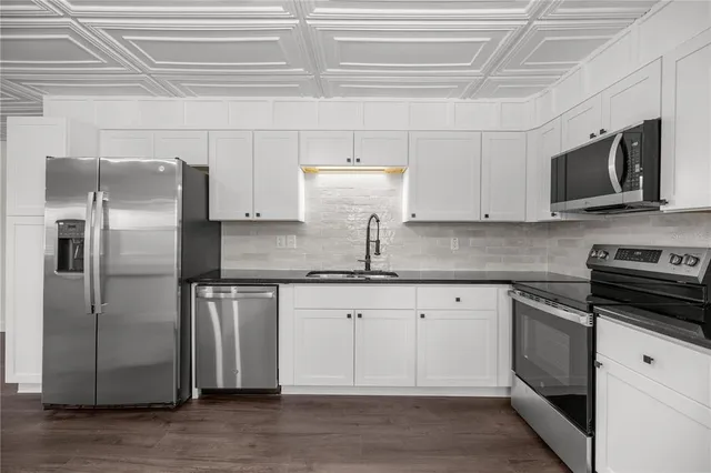 a kitchen with stainless steel appliances granite countertop a refrigerator and a stove top oven