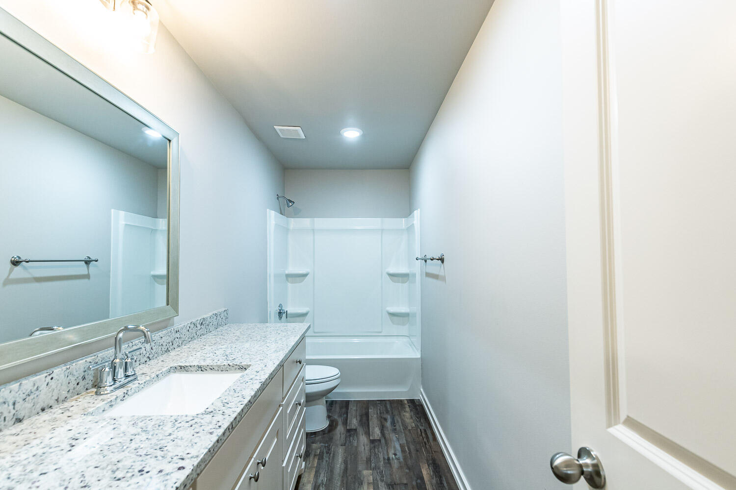 5508 122nd Street Lubbock, TX 79424 - Photo 11 of 20 a bathroom with a granite countertop sink a toilet and a large mirror