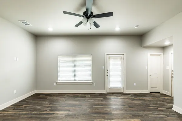 an empty room with window and a ceiling fan