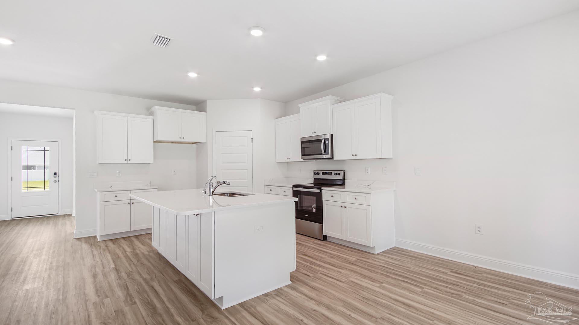 3233 Harrier Road Pace, FL 32571 - Photo 38 of 50 a kitchen with stainless steel appliances a sink a stove a refrigerator cabinets and a wooden floor