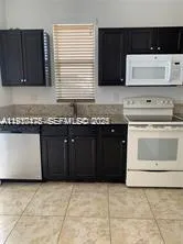 a kitchen with granite countertop a stove a sink and a microwave