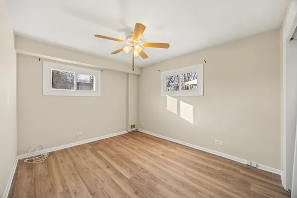 a view of an empty room with window and wooden floor