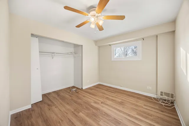 a view of a room with wooden floor and a ceiling fan