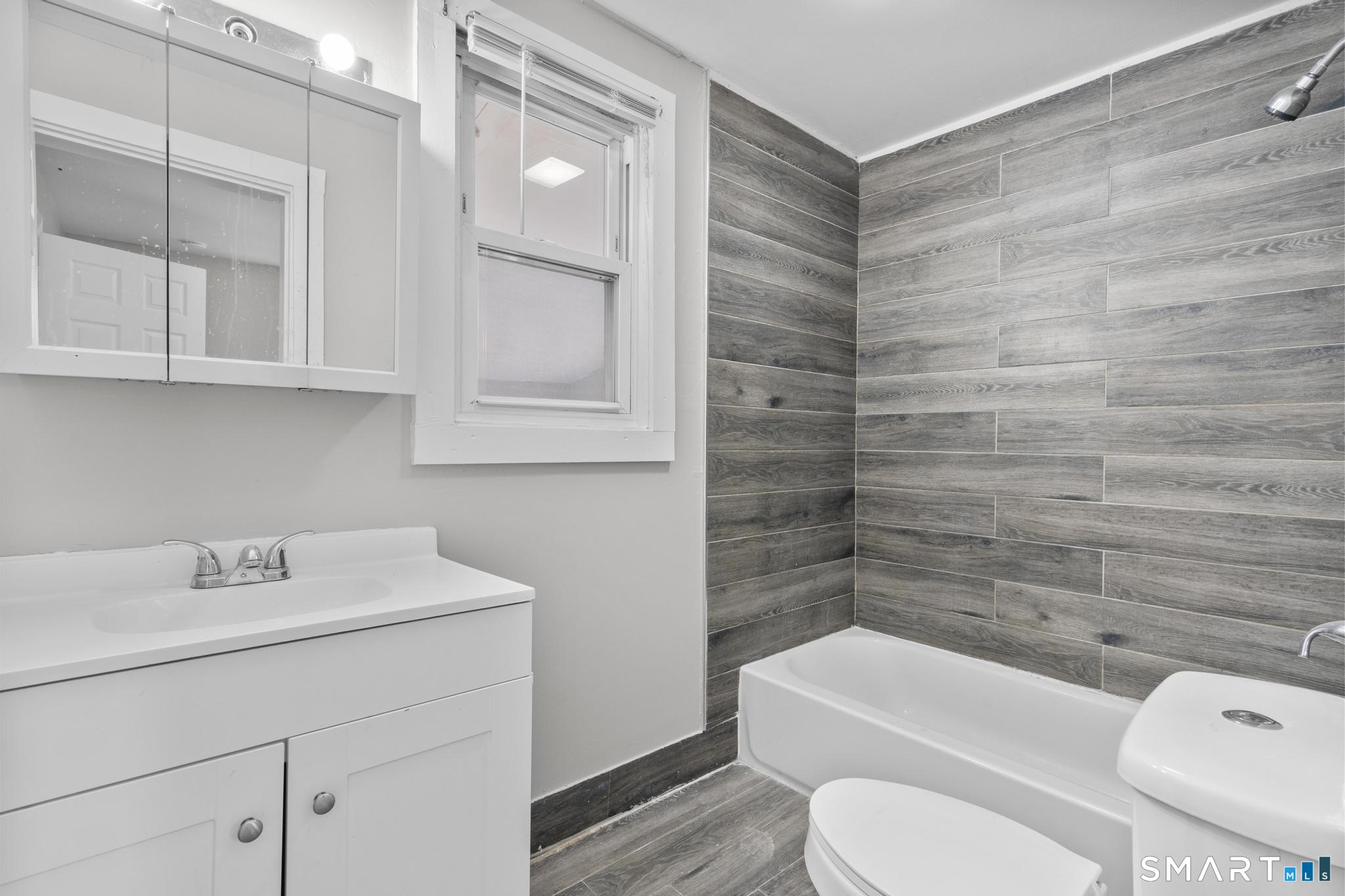 68 Whiting Street Hamden, CT 06514 - Photo 12 of 25 a bathroom with a sink a toilet and shower