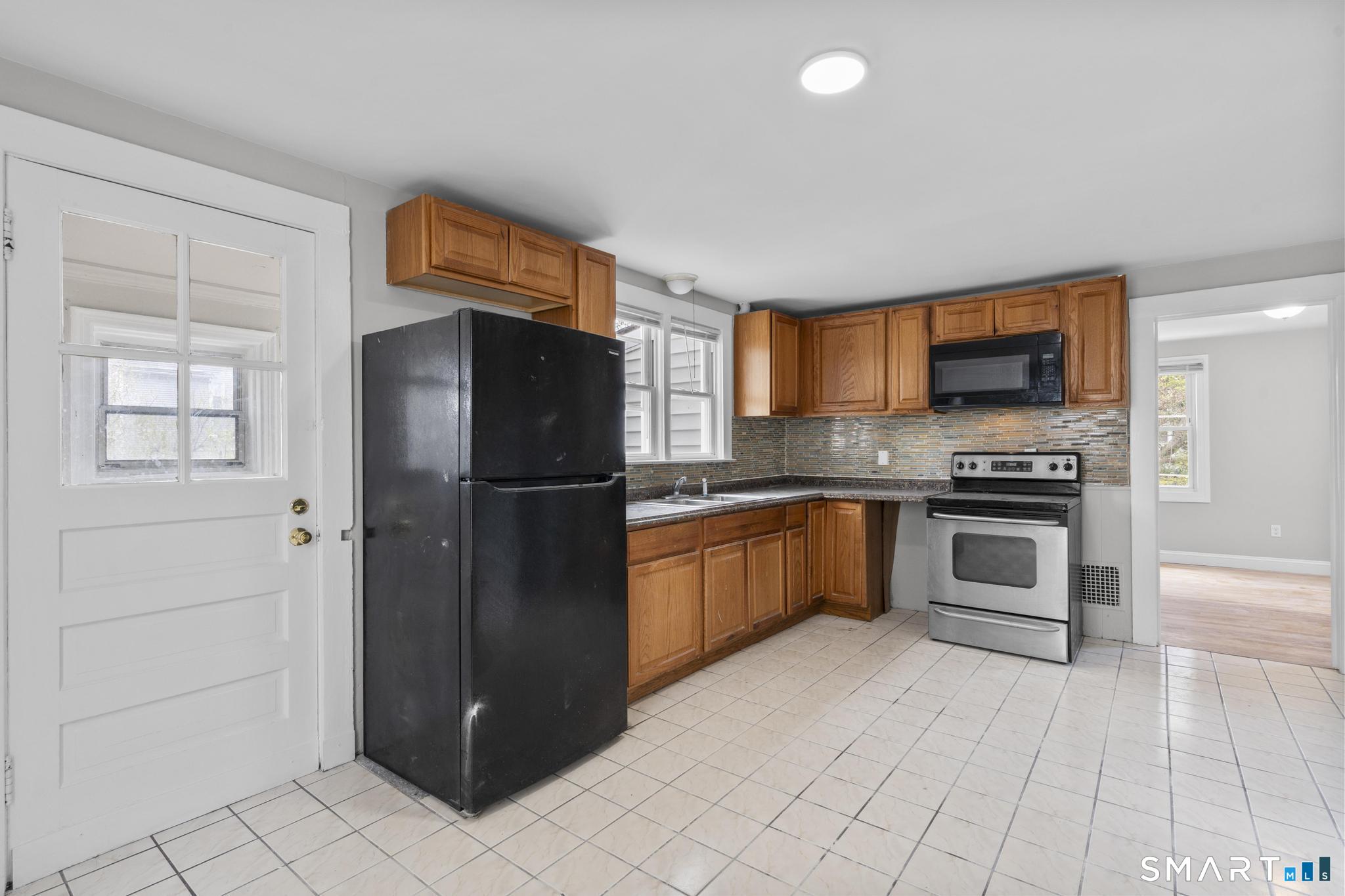 68 Whiting Street Hamden, CT 06514 - Photo 8 of 25 a kitchen with granite countertop a refrigerator and a stove top oven