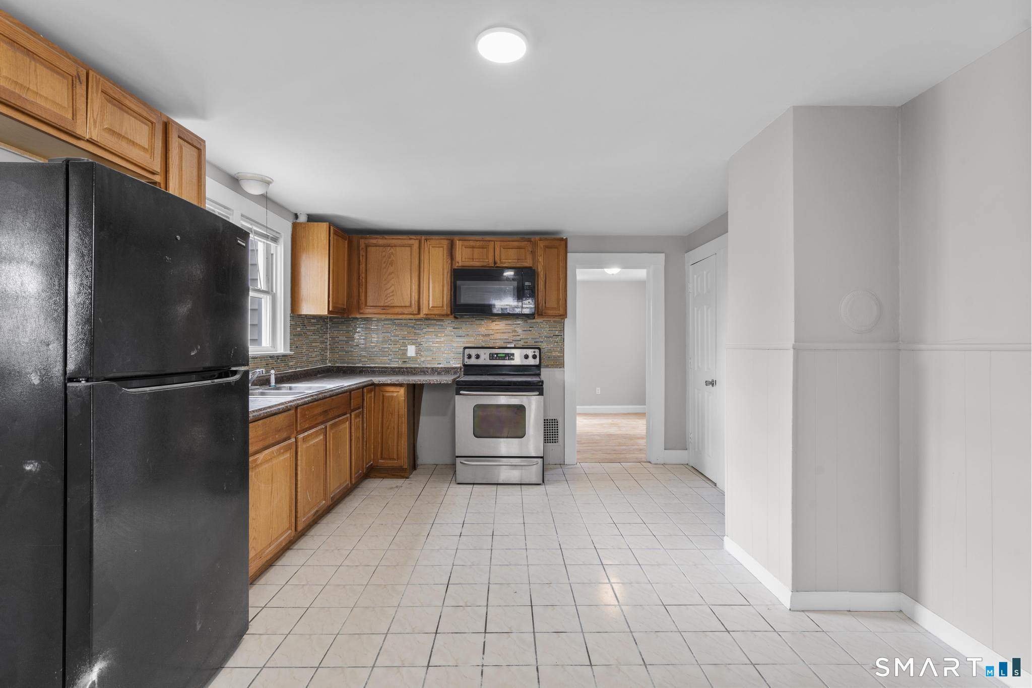 68 Whiting Street Hamden, CT 06514 - Photo 9 of 25 a kitchen with stainless steel appliances granite countertop a refrigerator a stove and a sink