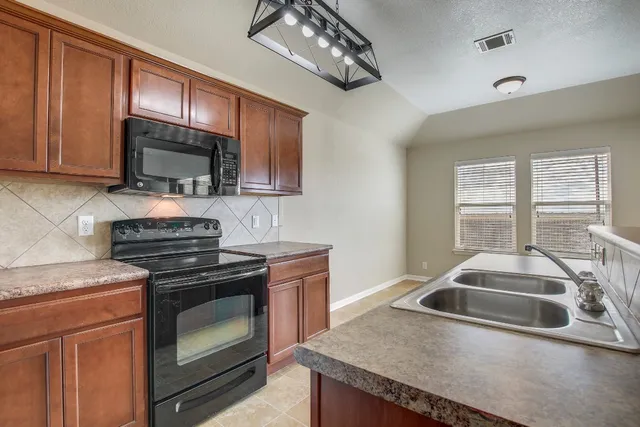 a kitchen with granite countertop a stove and a sink