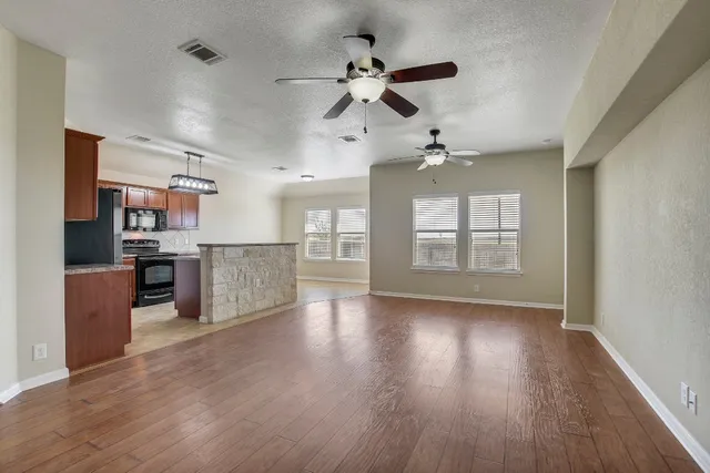 a view of a kitchen with wooden floor and a window