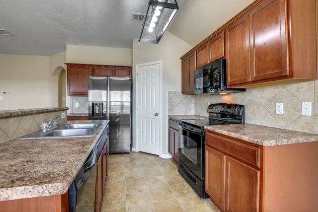 a kitchen with stainless steel appliances granite countertop a sink stove and refrigerator