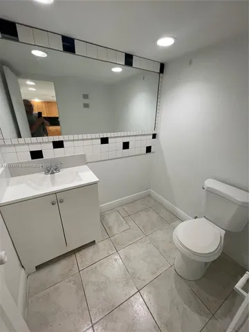 a bathroom with a sink toilet and mirror
