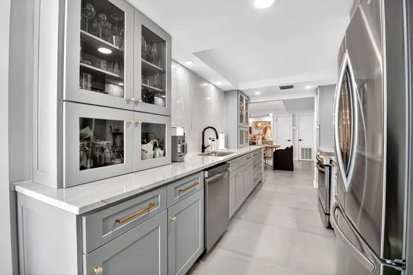 a kitchen with stainless steel appliances granite countertop a refrigerator and a sink