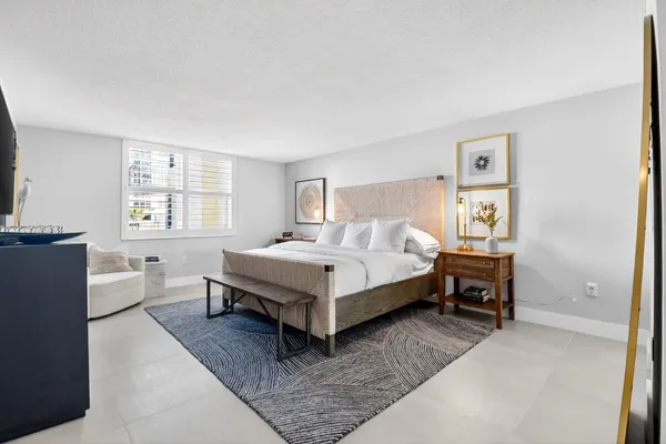 a bedroom with a bed chair and window