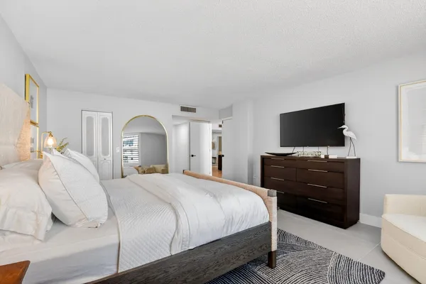 a bedroom with a bed and a flat screen tv