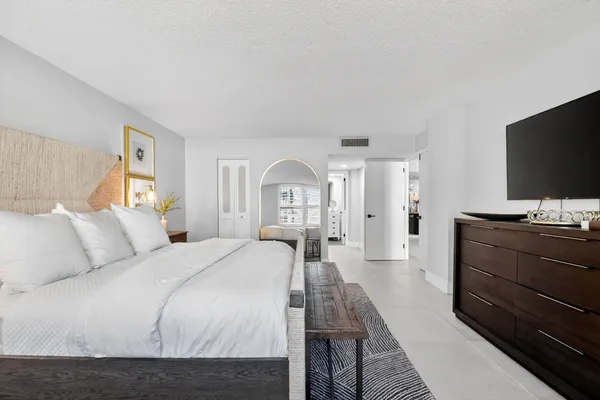 a bedroom with a bed and a flat screen tv