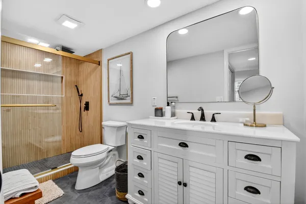 a spacious bathroom with a granite countertop sink toilet and shower