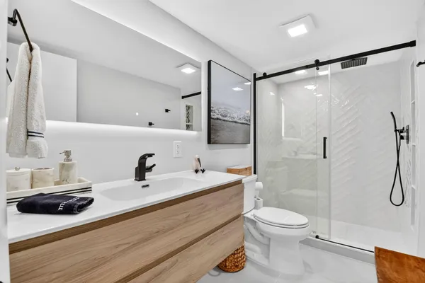 a bathroom with a sink a toilet and shower