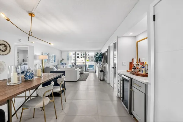 a kitchen with stainless steel appliances kitchen island granite countertop a table chairs in it and a window