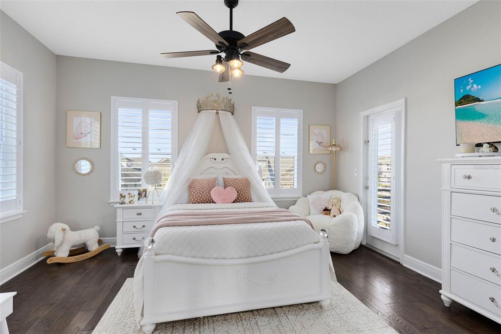 9374 Reymont Street Orlando, FL 32827 - Photo 21 of 54 a spacious bedroom with a bed and a chandelier