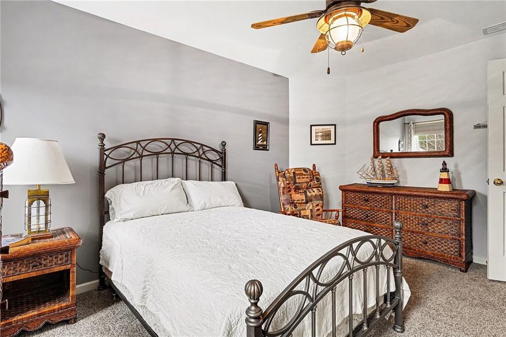 174 Senators Ridge Drive Dallas, GA 30132 - Photo 19 of 26 a bedroom with a bed a dresser and a chandelier