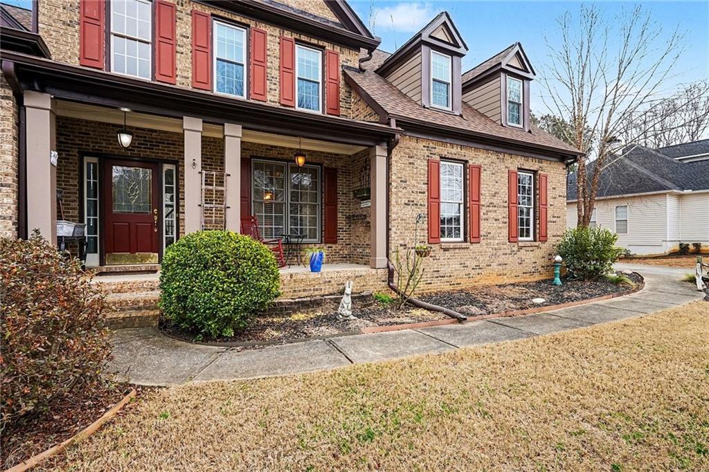 174 Senators Ridge Drive Dallas, GA 30132 - Photo 4 of 26 front view of a brick house with a large window and potted plants