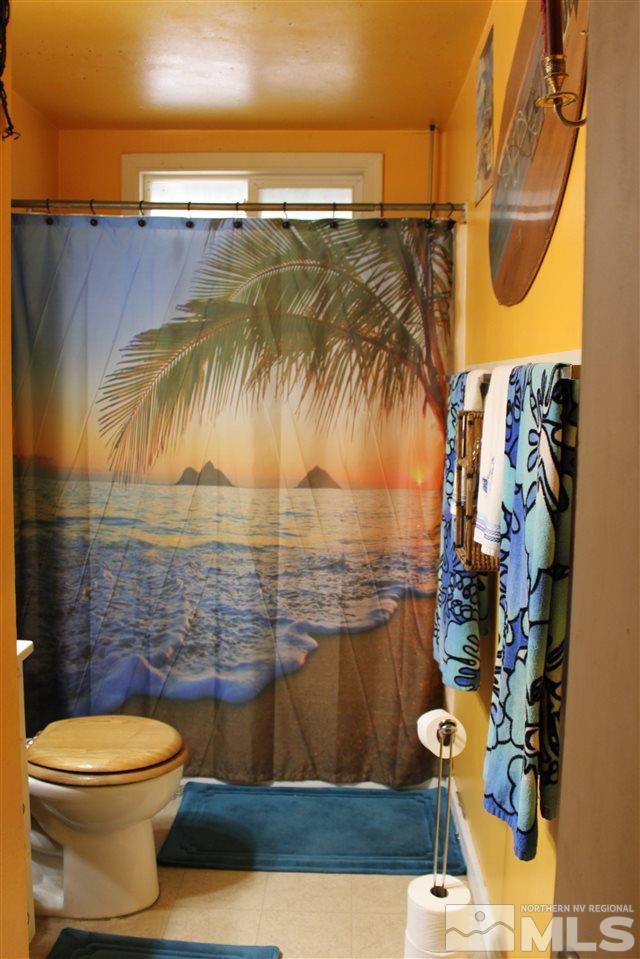 9190 Fremont Way Reno, NV 89506 - Photo 3 of 8 a bathroom with a toilet and a shower curtain