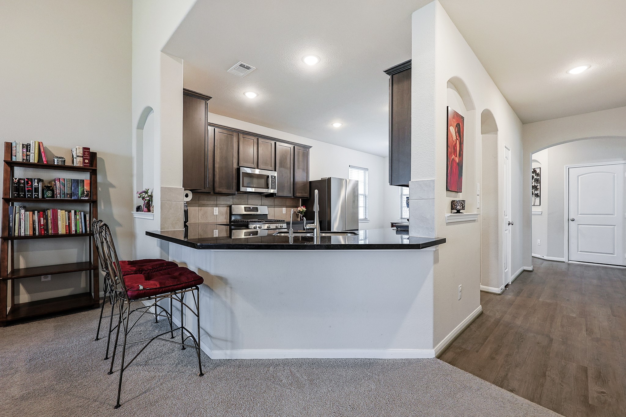 10423 Rochester Hls Lane Tomball, TX 77375 - Photo 15 of 36 The modern kitchen features an expansive, wrap-around breakfast bar with sleek polished countertops that overlook the main living spaces--providing the perfect setup for casual dining, quick morning coffees, or entertaining guests.