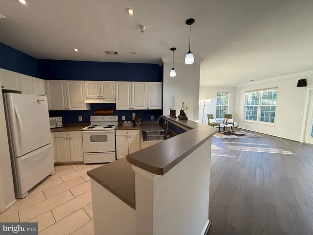 a kitchen with granite countertop a refrigerator stove top oven and cabinets