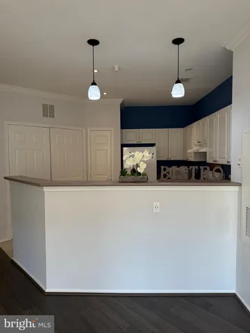 a kitchen with stainless steel appliances a refrigerator and a wooden floor