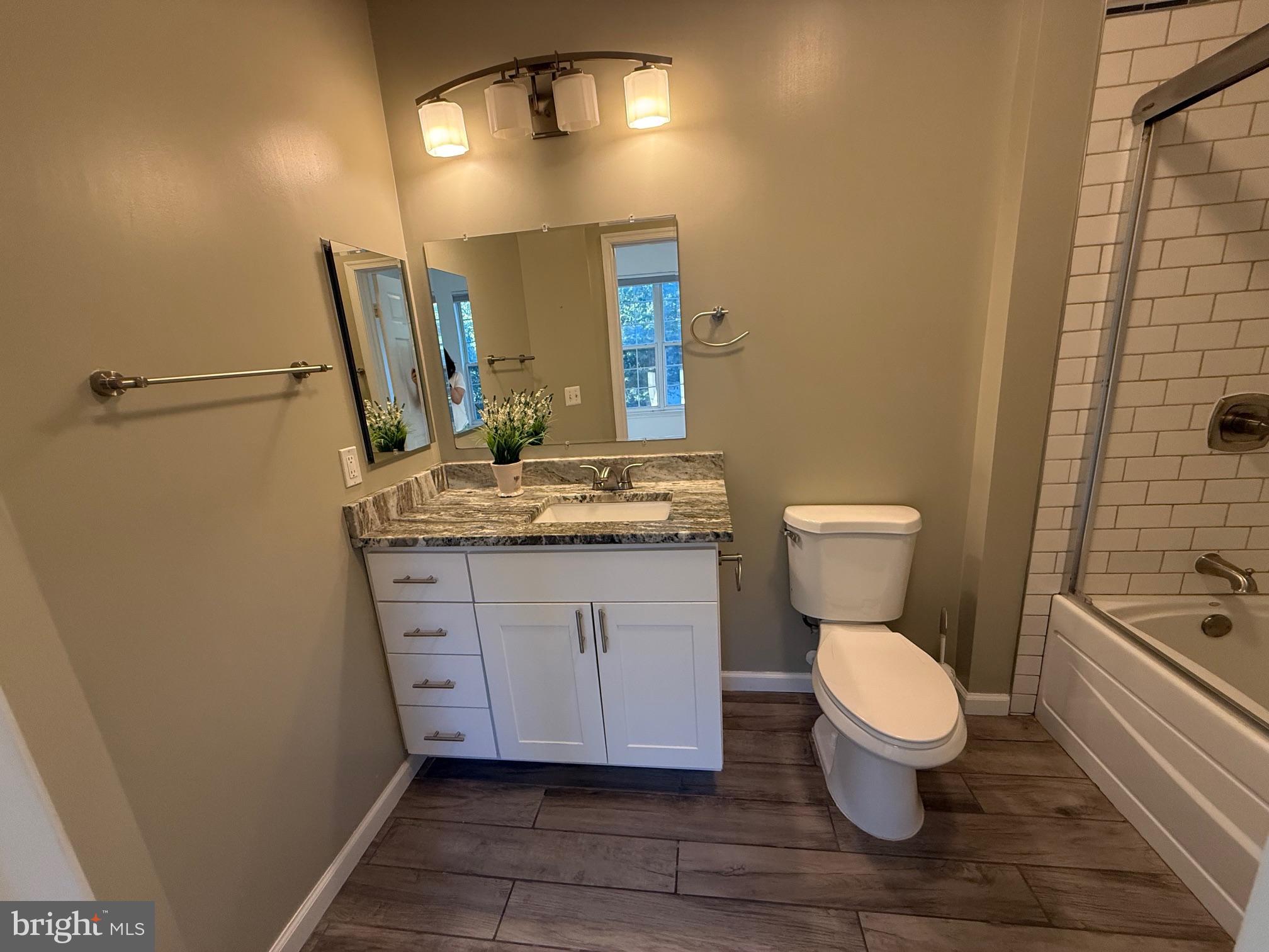 3009 Nicosh Circle, Unit 4302 Falls Church, VA 22042 - Photo 15 of 32 a bathroom with a granite countertop toilet sink and mirror
