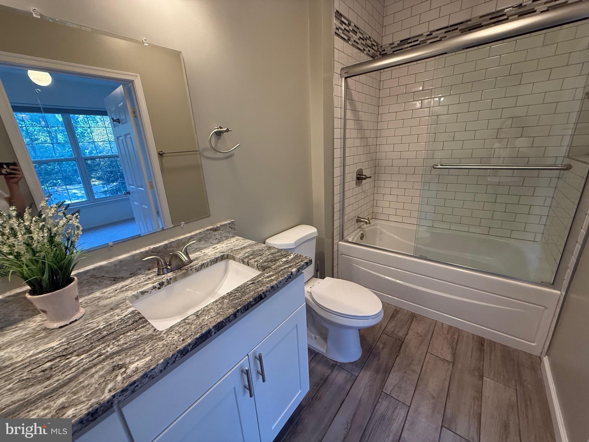 3009 Nicosh Circle, Unit 4302 Falls Church, VA 22042 - Photo 16 of 32 a bathroom with a granite countertop toilet a sink and shower