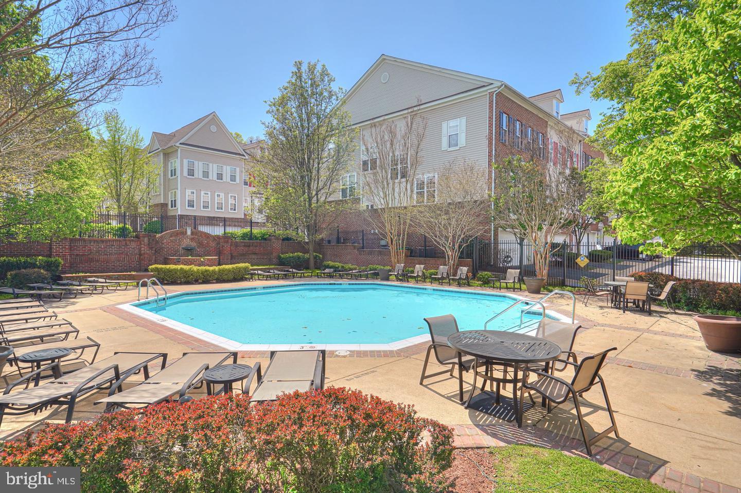 3009 Nicosh Circle, Unit 4302 Falls Church, VA 22042 - Photo 29 of 32 a view of a swimming pool with lawn chairs under an umbrella