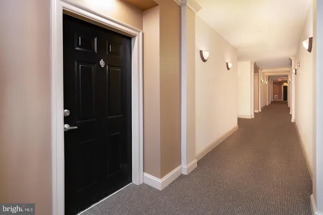 a view of a hallway with closet and a bathroom